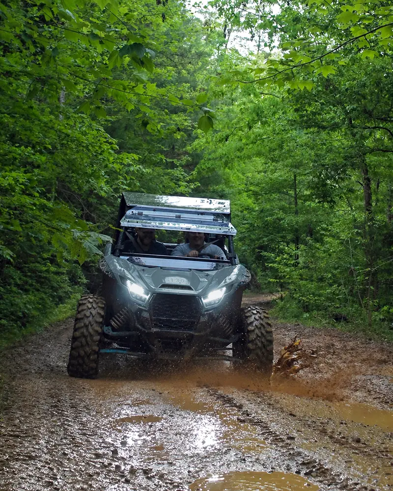 UTV splashing through mud on a guided off-road tour near Pigeon Forge